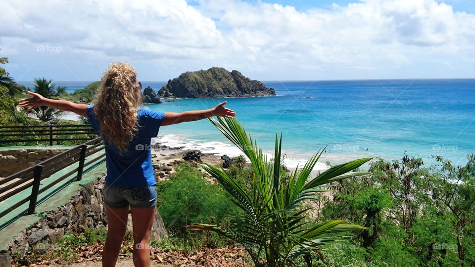 Woman looking the beach in a sun day . Fernando de Noronha island. Brazil 