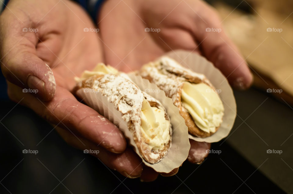 Man holding home made Traditional cannoli Italian sweet deserts 