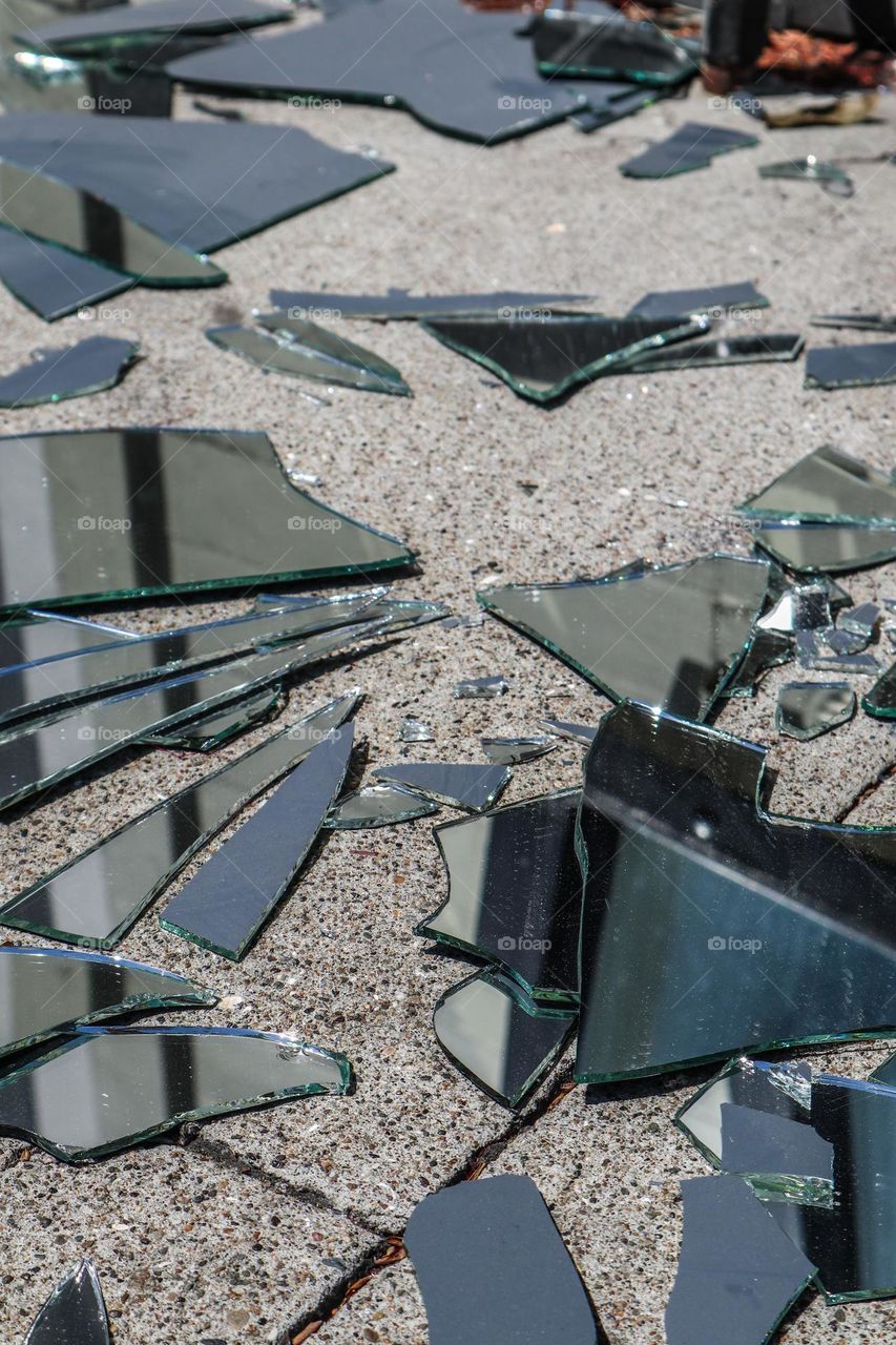 Reflection of a building on a sidewalk in a broken mirror on the streets of San Francisco, resembling a cubist painting, fractured and abstract 