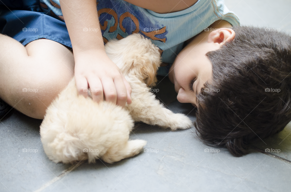 Boy petting his puppy 