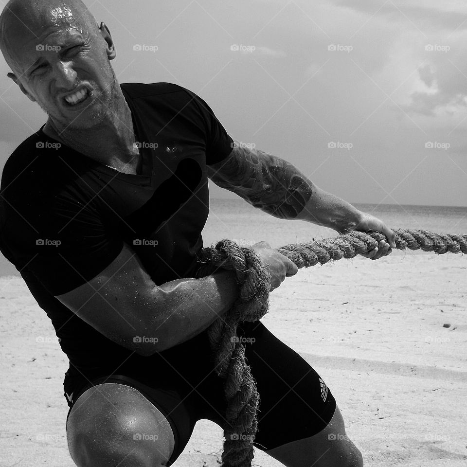 Man pulling rope on beach