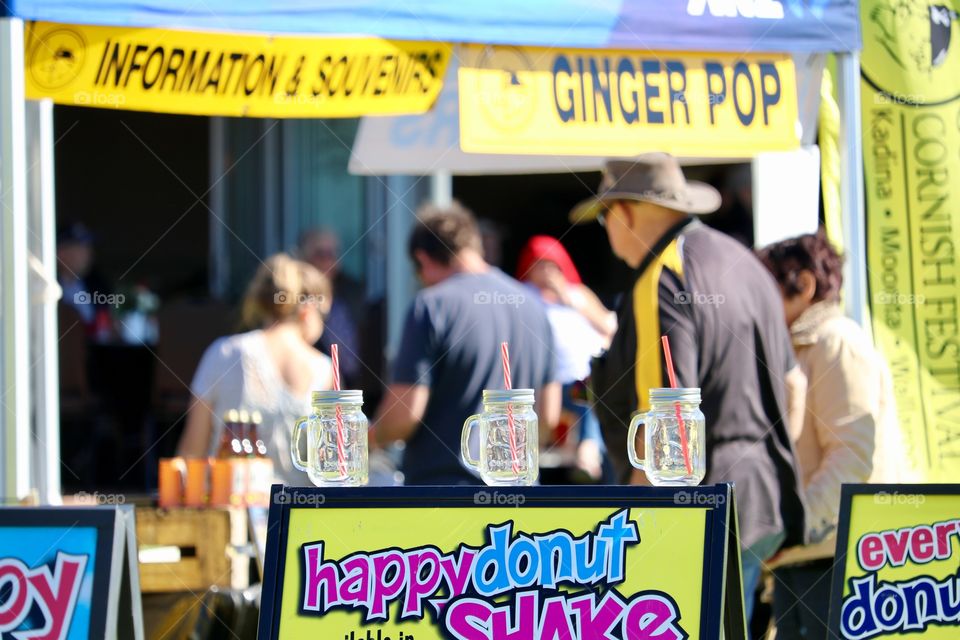 Festival food concession food fair, three clear glass mason jar mugs lined up in a row atop a sandwich board 