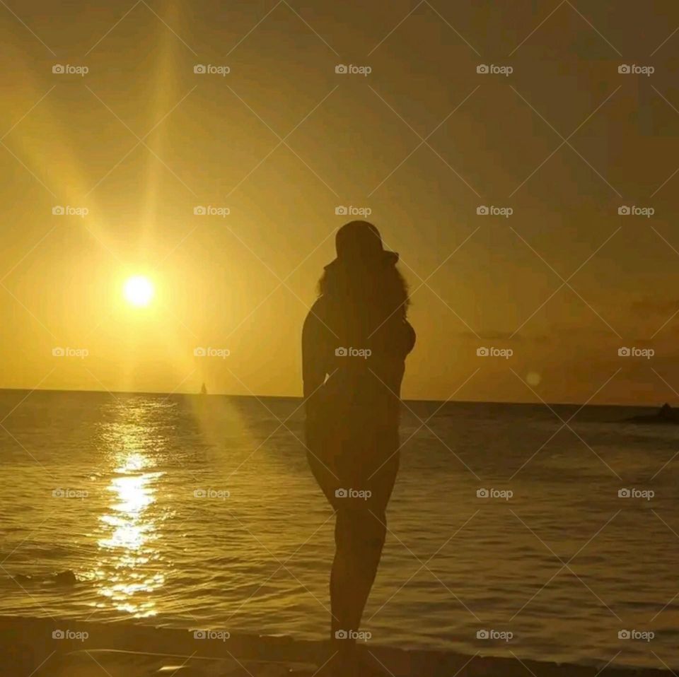 A girl contemplating the sunset and the reflection of light over the sea.