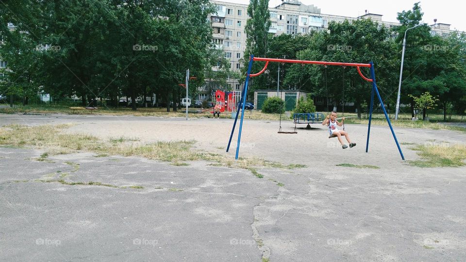 boy swinging on a swing at the playground