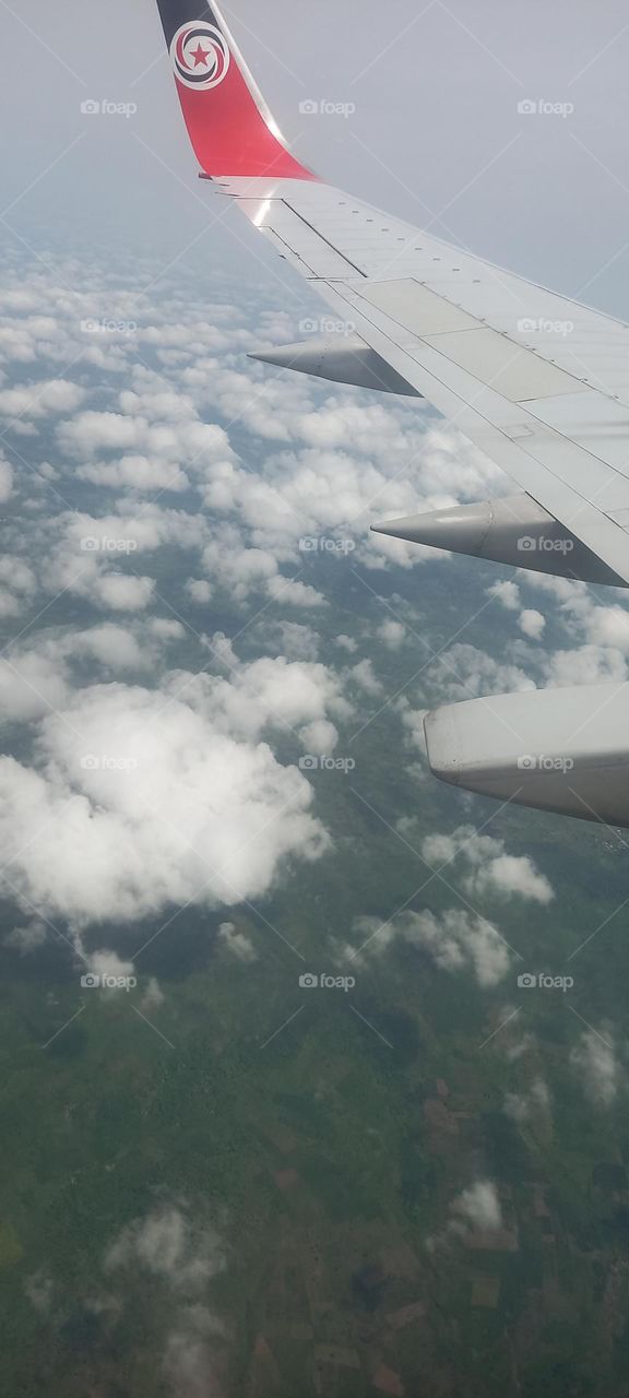 Awesome Window seat view of aircraft in the air. Clouds visible, aircraft wing visible.