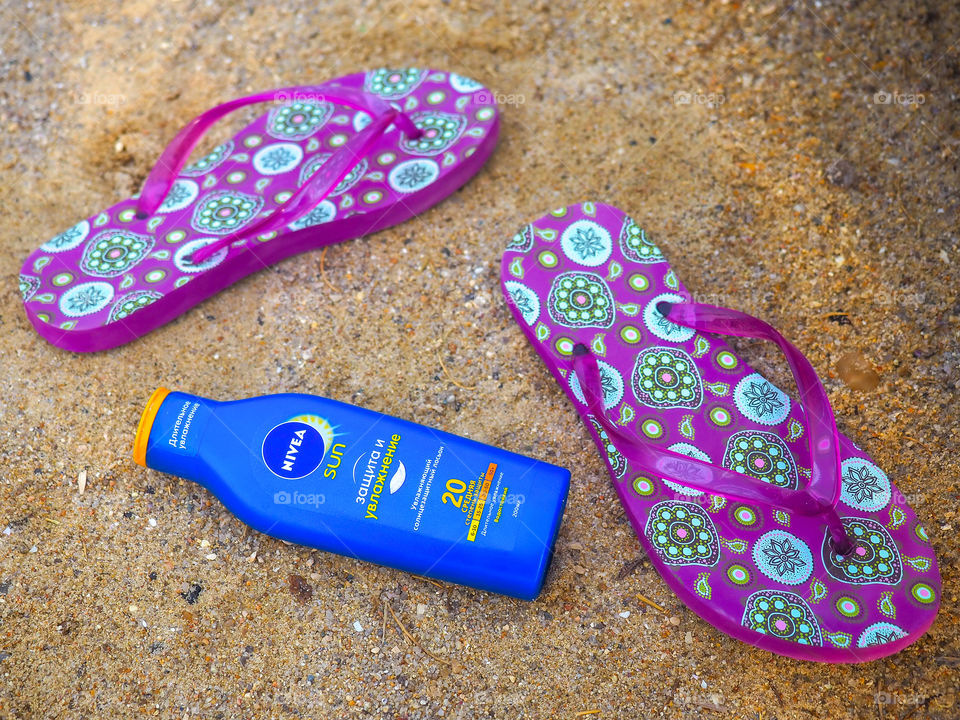 Moisturizing sunscreen lotion with an average degree of protection "NIVEA" on a sunny sandy beach.
