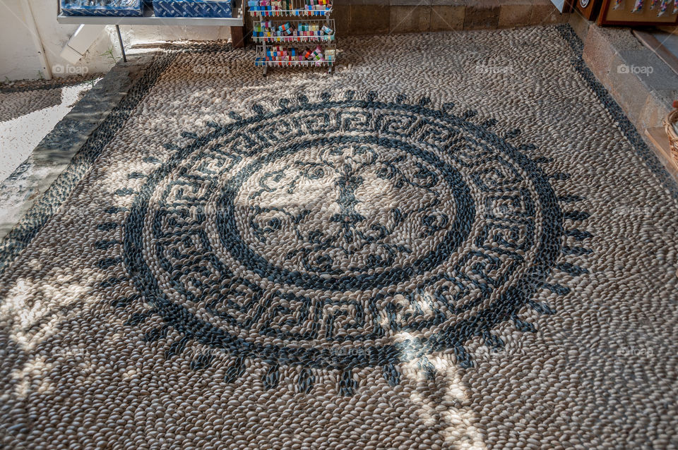 Beautifully decorated mosaic footpath with black and white sea pebbles. Lindos town on Island of Rhodes. Greece. Europe.