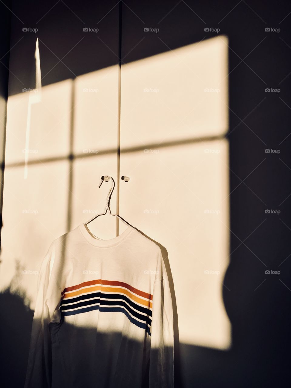 Rainbow sweater hanging on closet