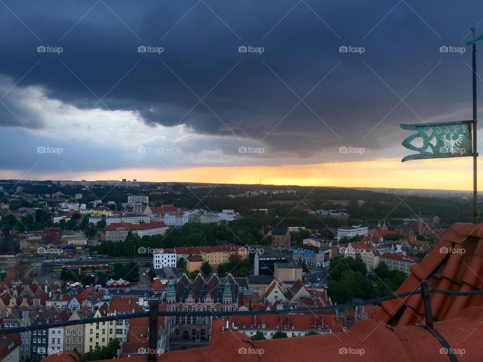 Cloudy Sunset over Gdansk and a flag