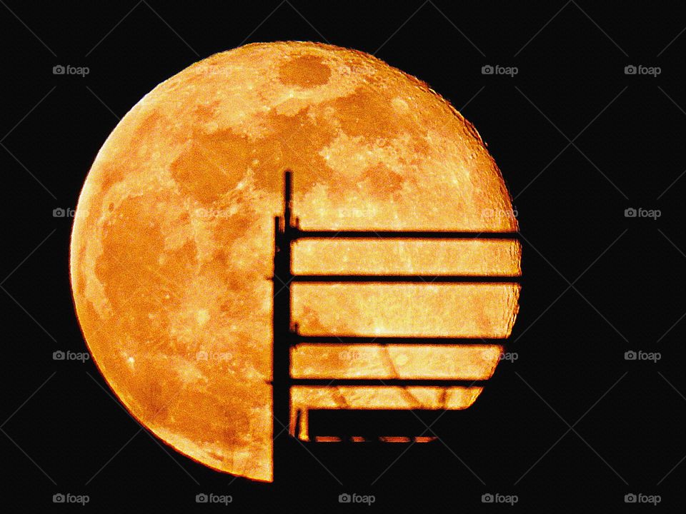 Sunrise, sunset and the moon - The bright full moon seen through the scaffolding shows the impact craters, and dead volcanoes 