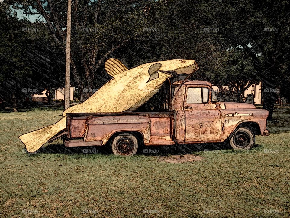 Old truck with a fish in back of it