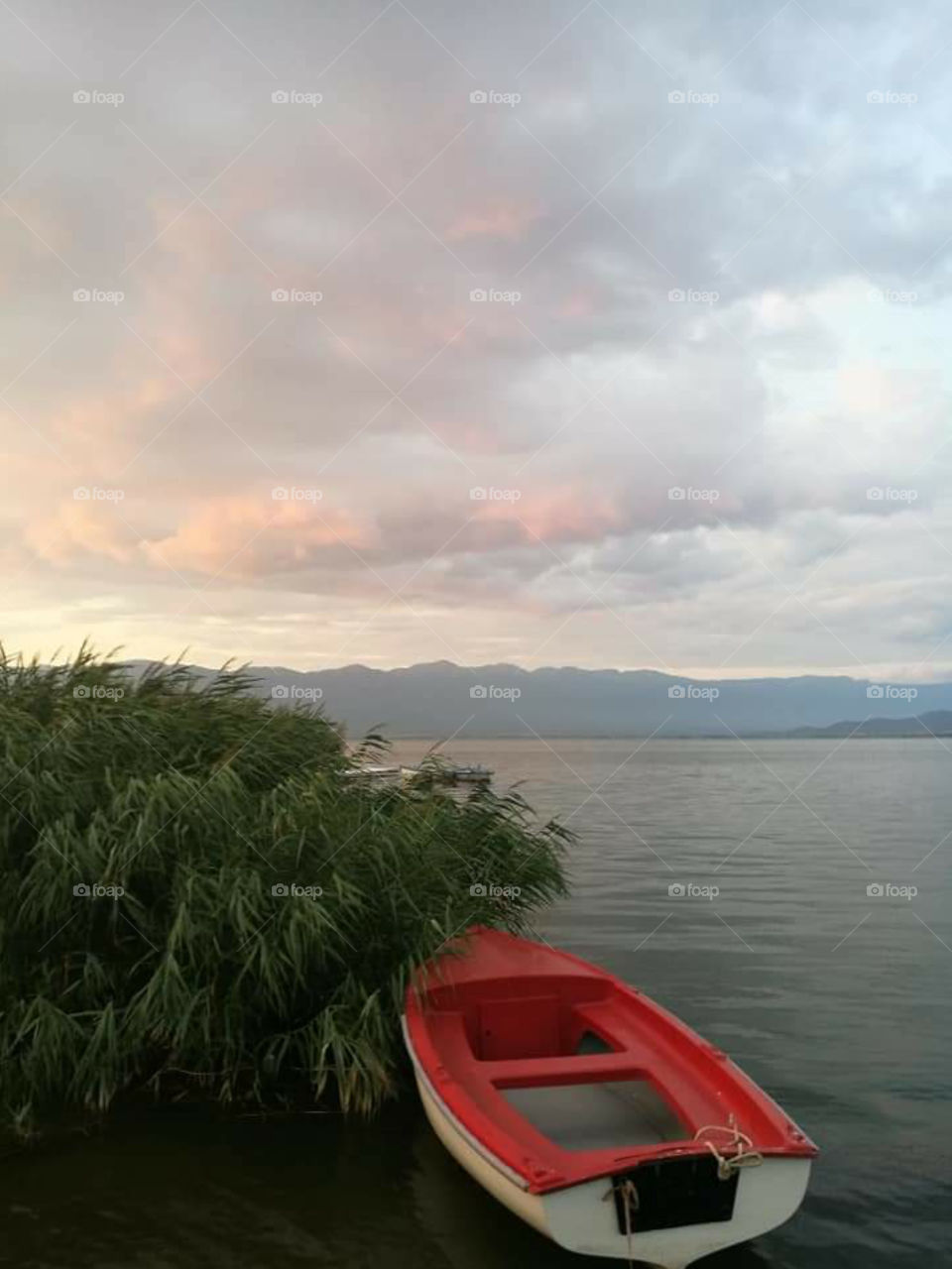 an anchored boat on the river at the end of the day