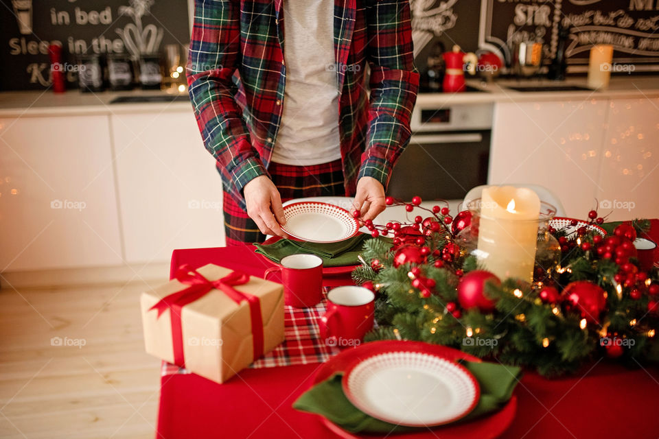 man sets a beautiful decorated winter table for a festive dinner.  Merry Christmas and Happy New Year.