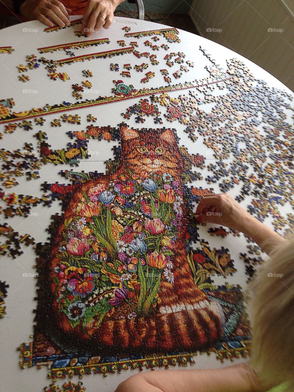 Peoples playing puzzle on table