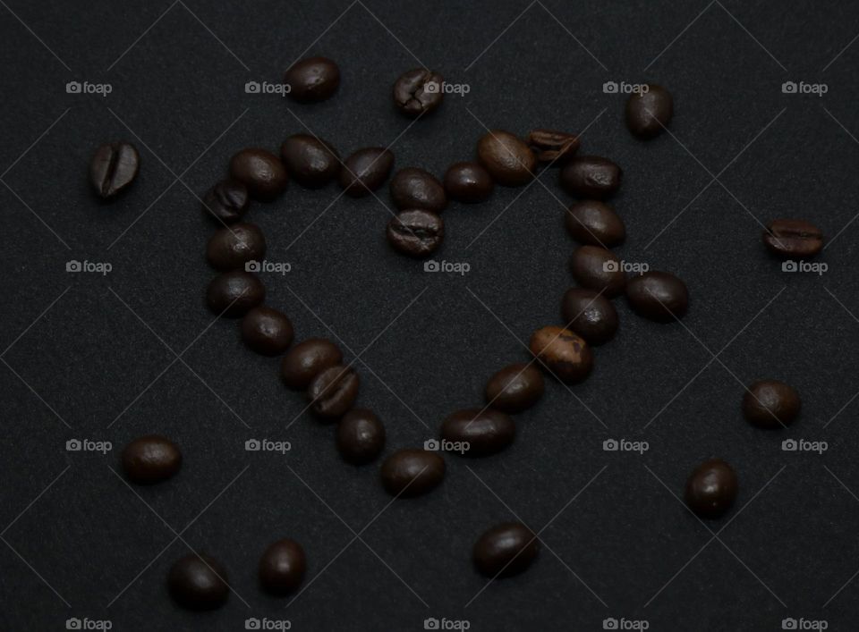 coffee beans on black background heart shape