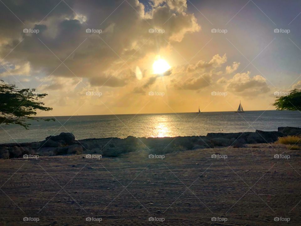 Sunset over the ocean, sailboat in background in Aruba during our UTV excursion with Carnival Sunshine Cruise 2018