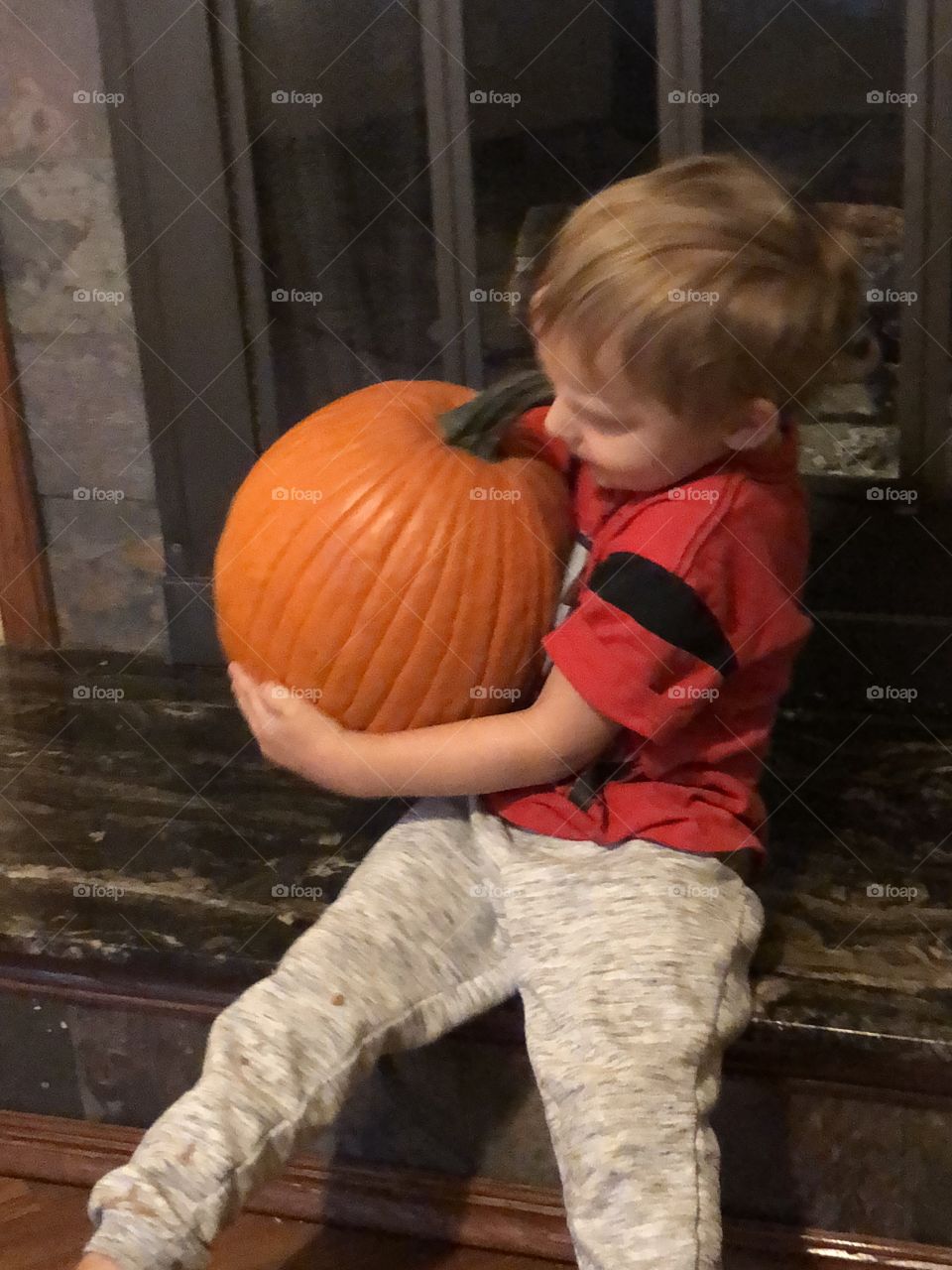Boy holds fat pumpkin