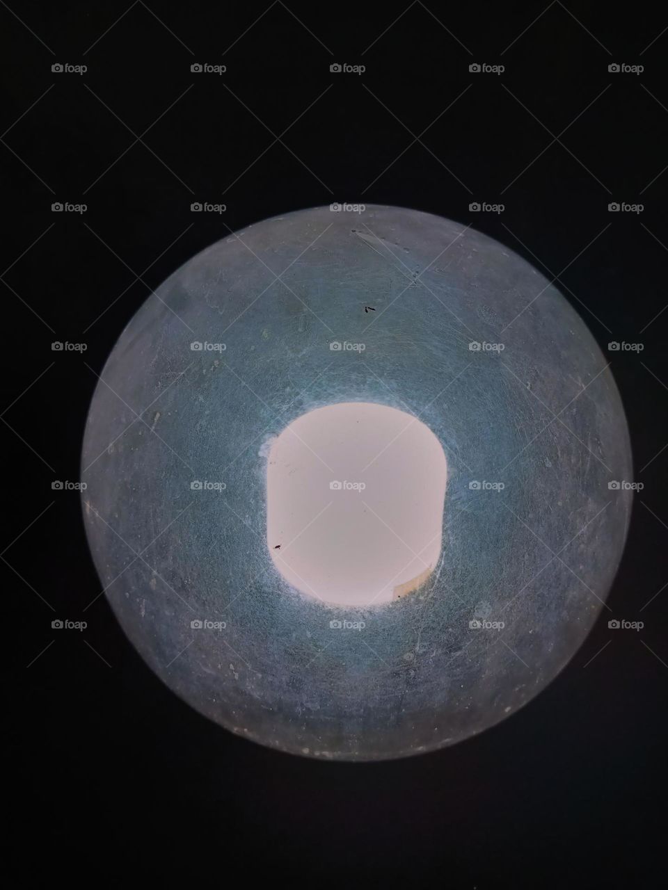 Close-up of round and transparent glass lamp on black background.