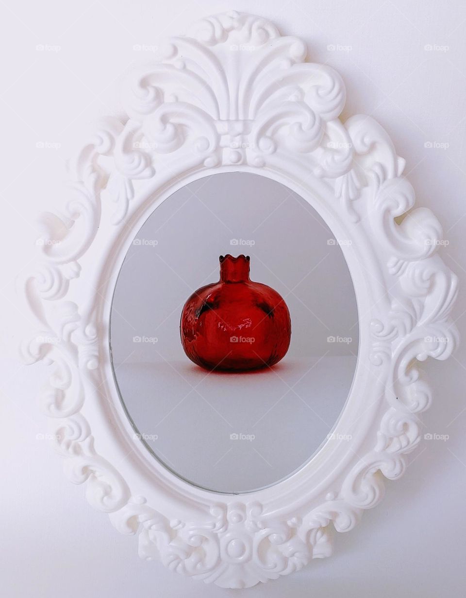 Pomegranate in a frame with a mirror