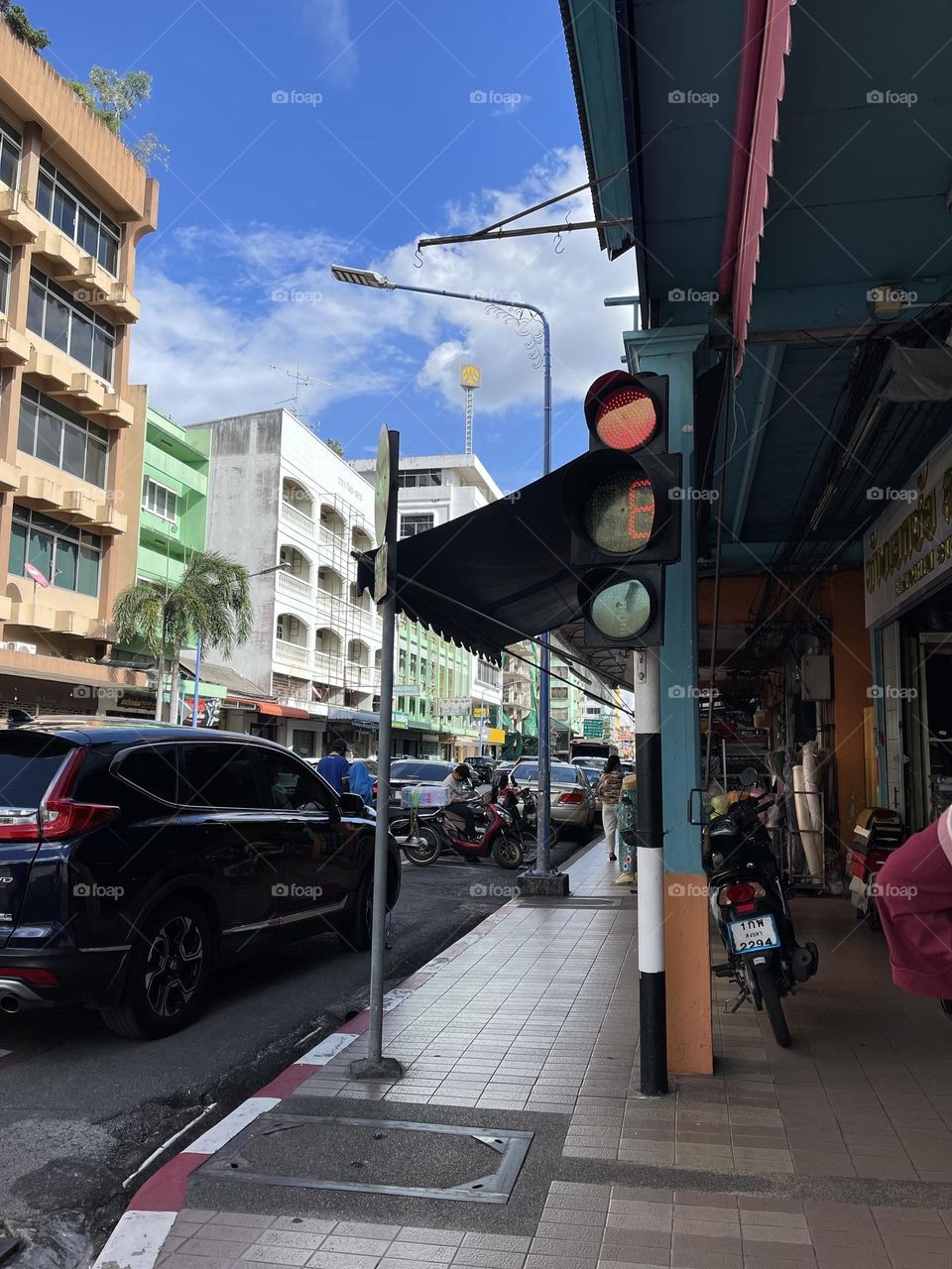 A traffic light on the road side in a city in Thailand
