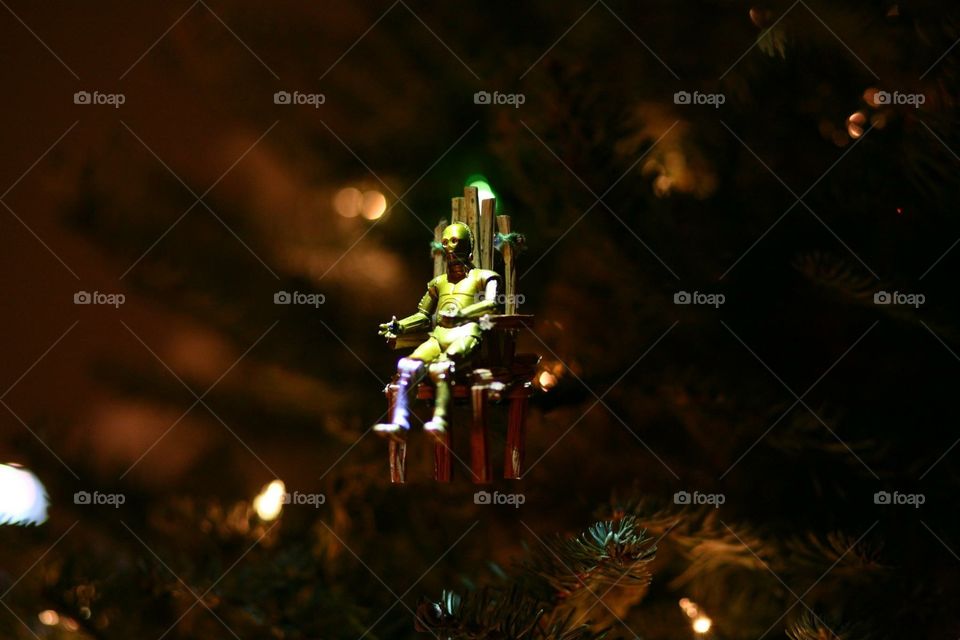 Star Wars Christmas tree decorated with C3PO on a chair in the air in Endor. 
