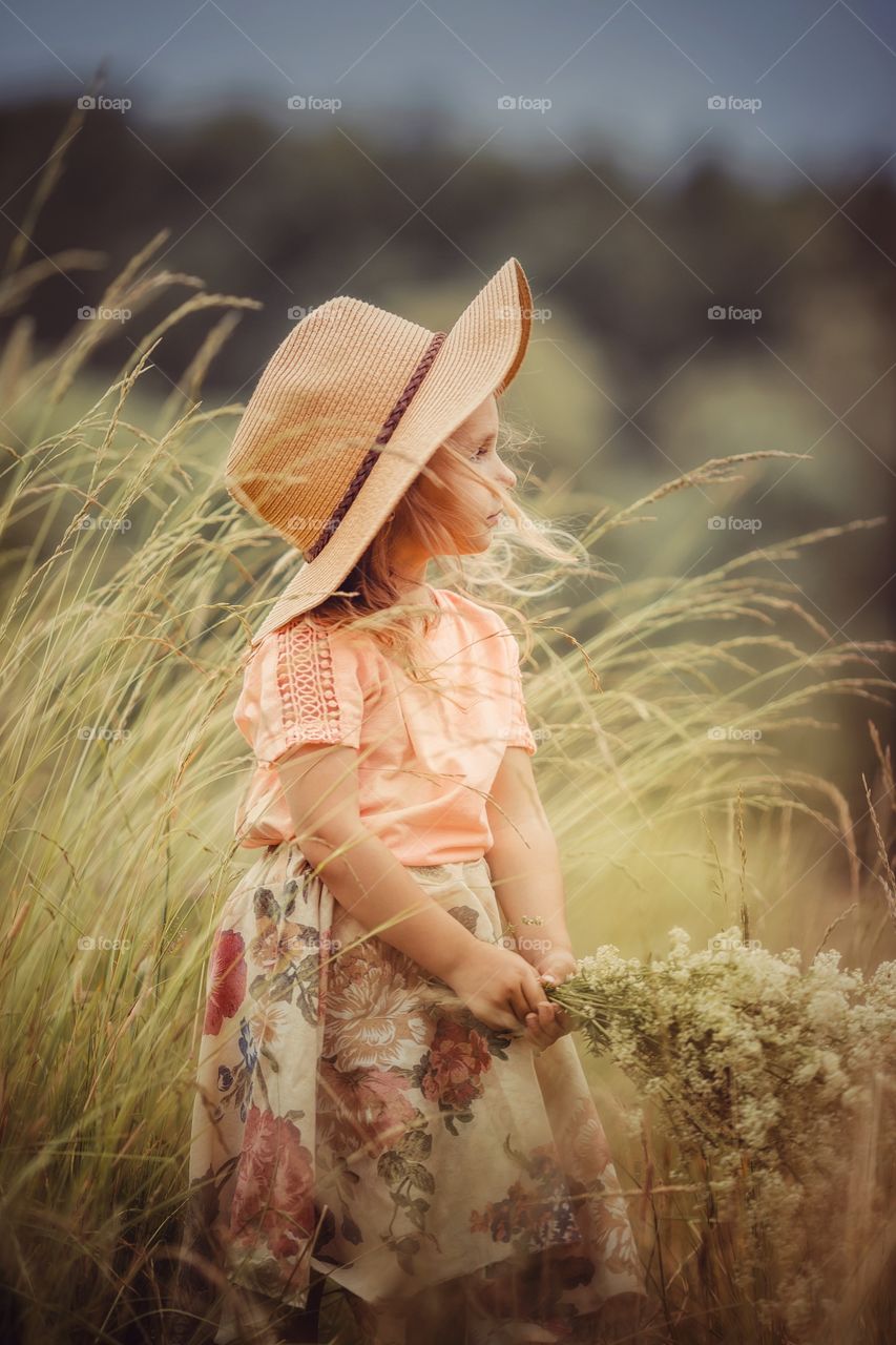 Little girl with bouquet of meadow flowers. 