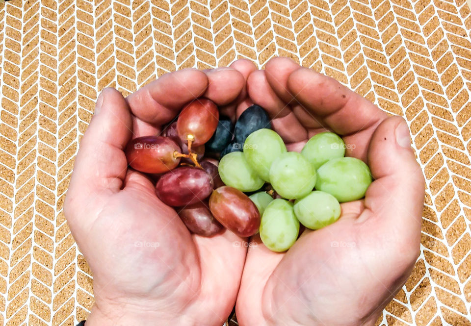 Close-up of a hand holding grapes