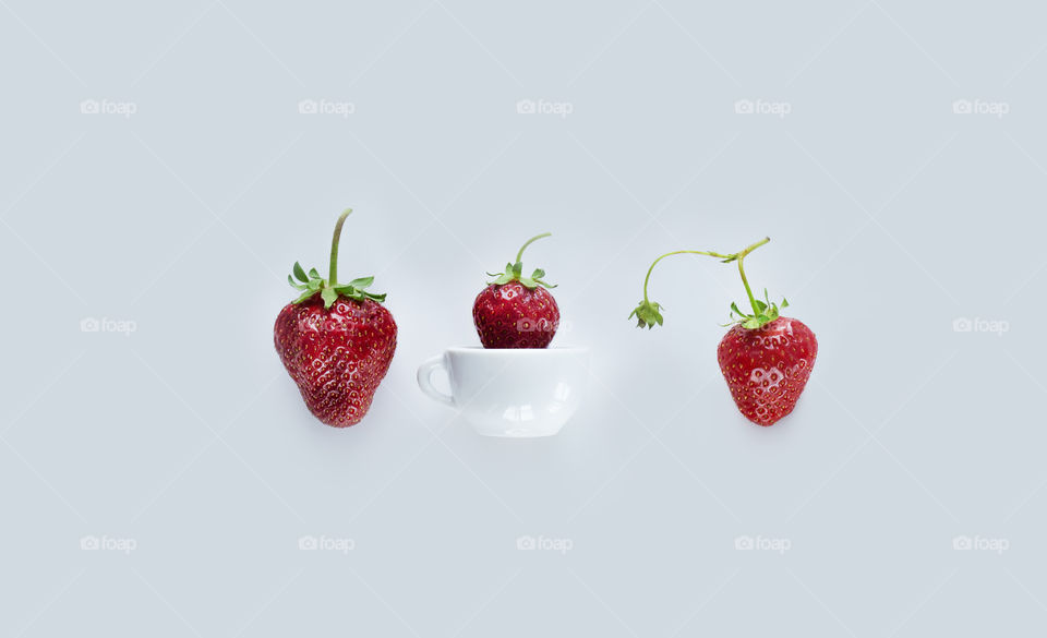 Strawberries on white background. Strawberry in tiny cup 