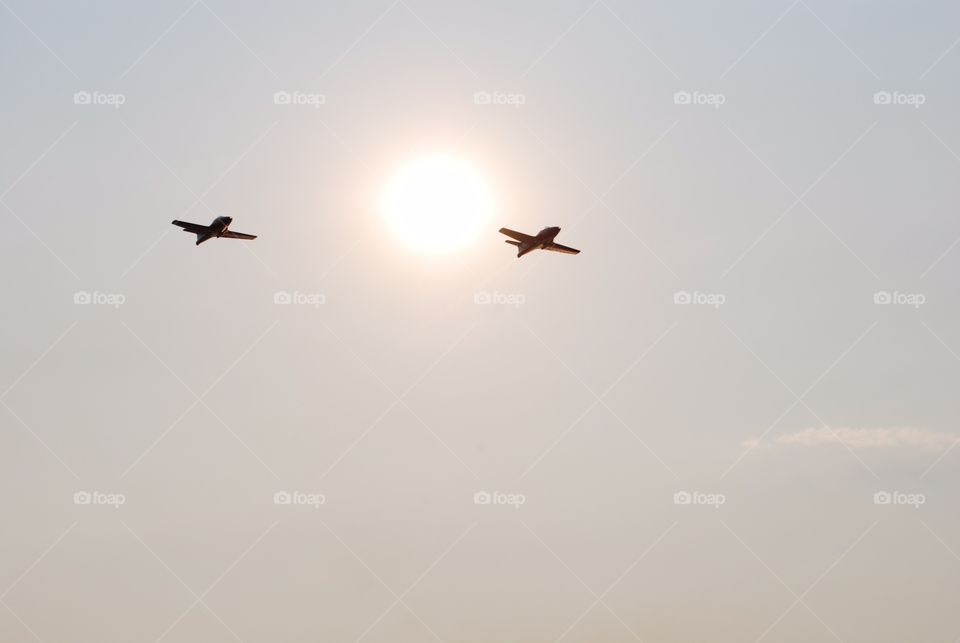 Silhouette of two airplanes flying in the sky