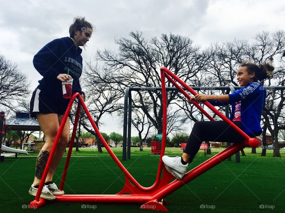 Woman and girl on playing on playground at park