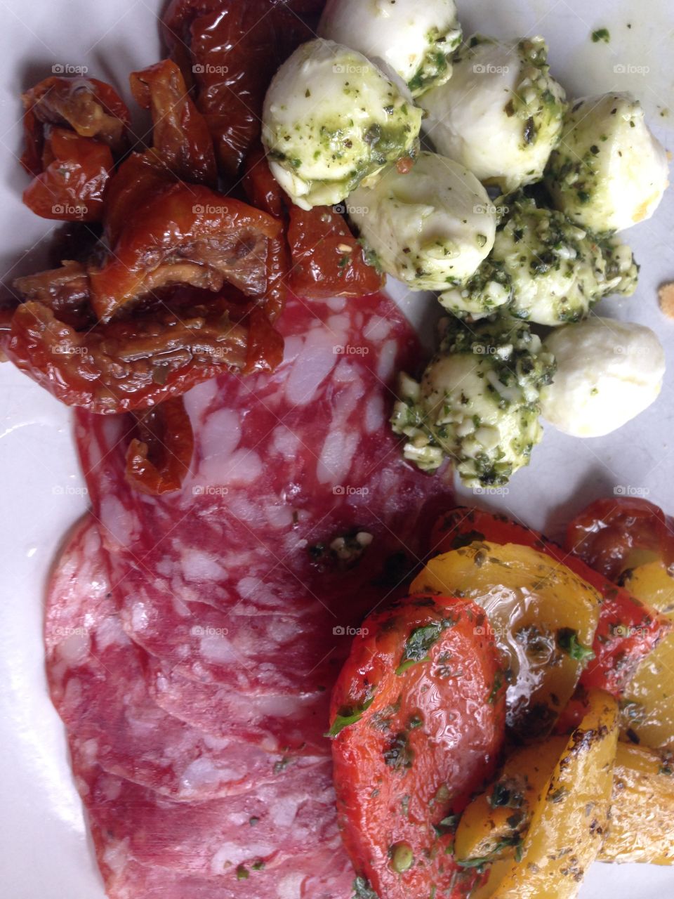 Italian antipasti salami boccichini cheese in pesto with roasted peppers 