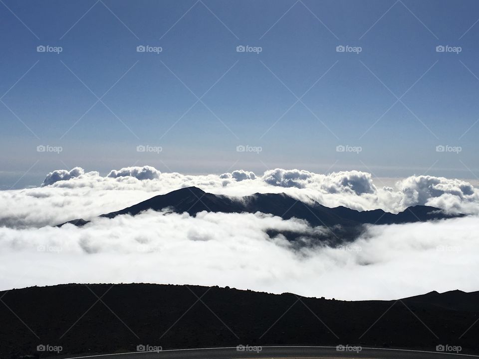 A breathtaking, stunning, early morning view over looking the clouds from the top of Mount Haleakala in Maui, Hawaii. 
