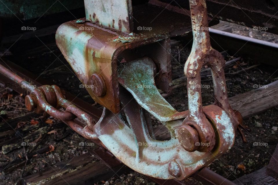 A rusty piece of a train on a train car sitting at the train station in New England.
