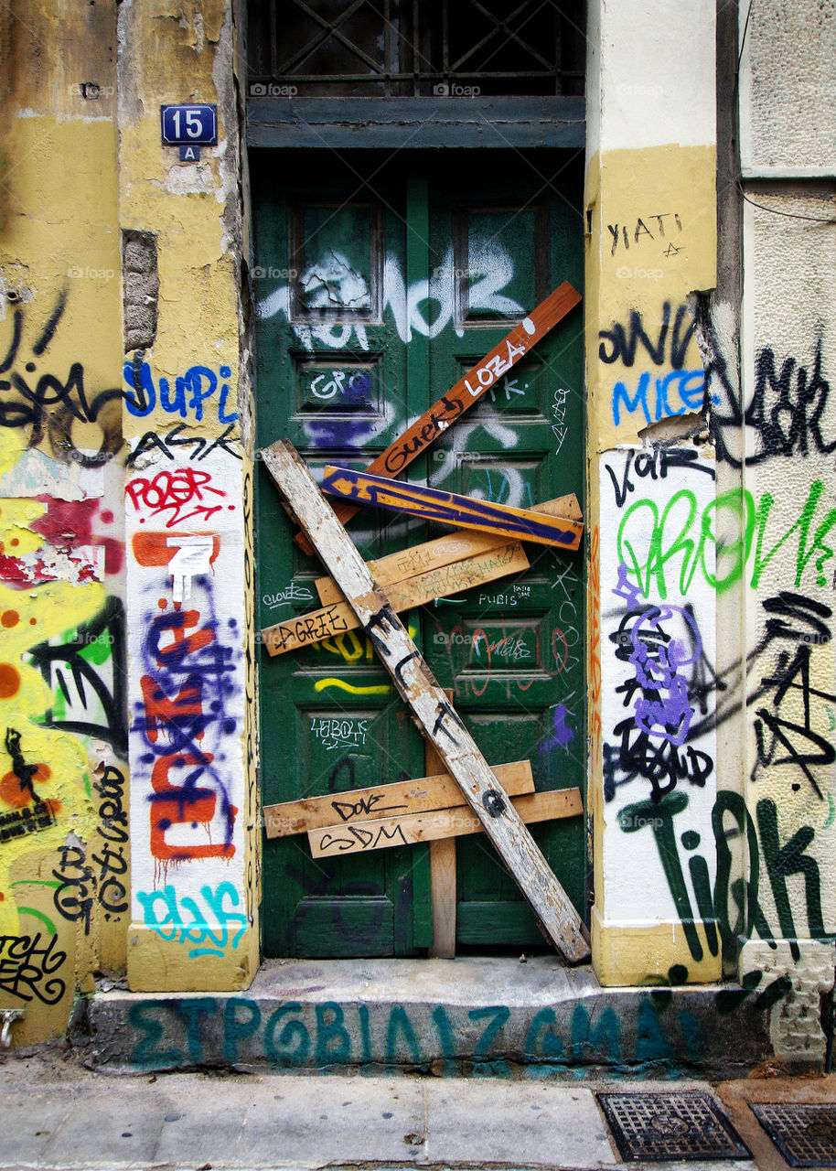 Boarded-up door with graffiti in Athens, Greece