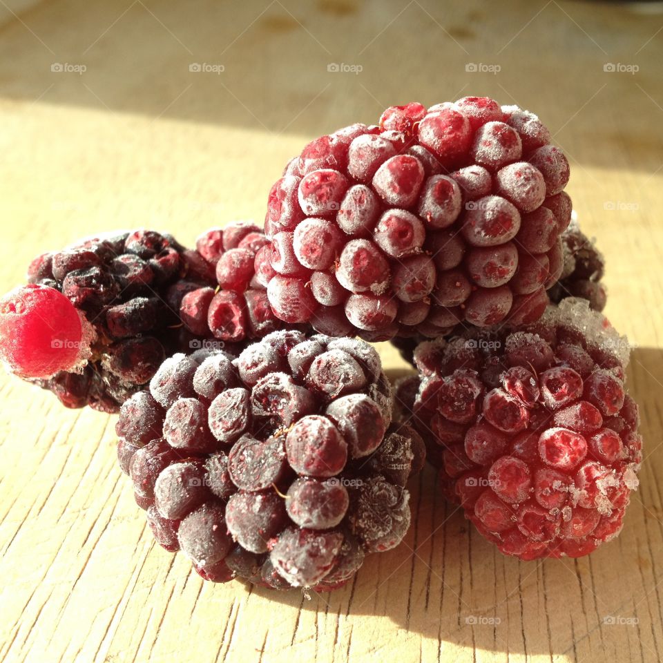 Frozen blackberries. A handful of frozen blackberries on a chopping board