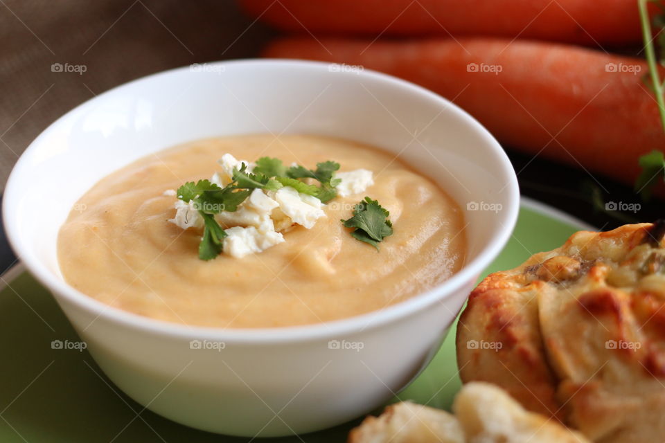 Carrot soup and feta cheese. Carrot soup and feta cheese in a white bowl with bread