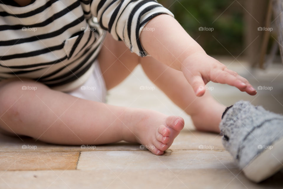 baby trying to put on her shoes