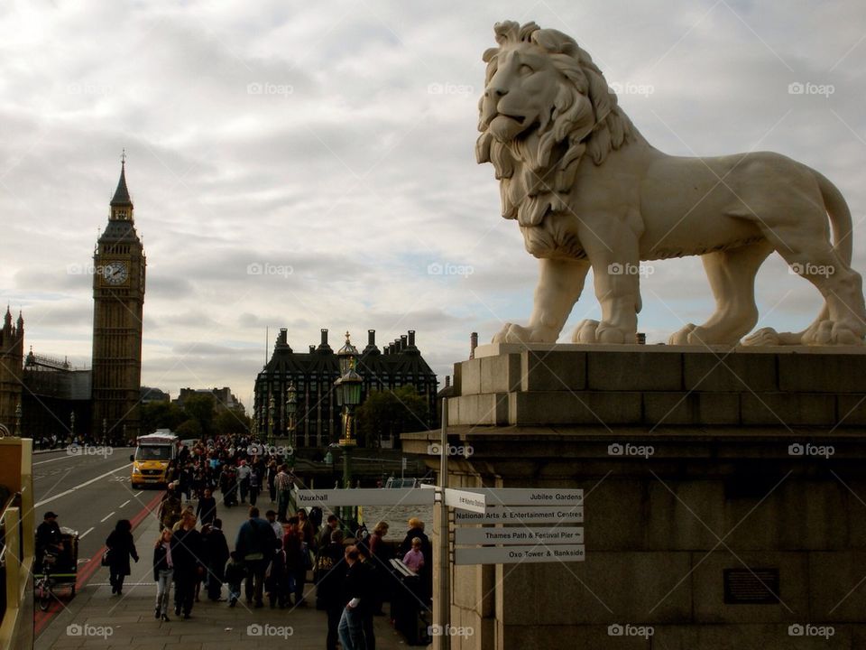 Lion standing guard with Big Ben in the background. London England 