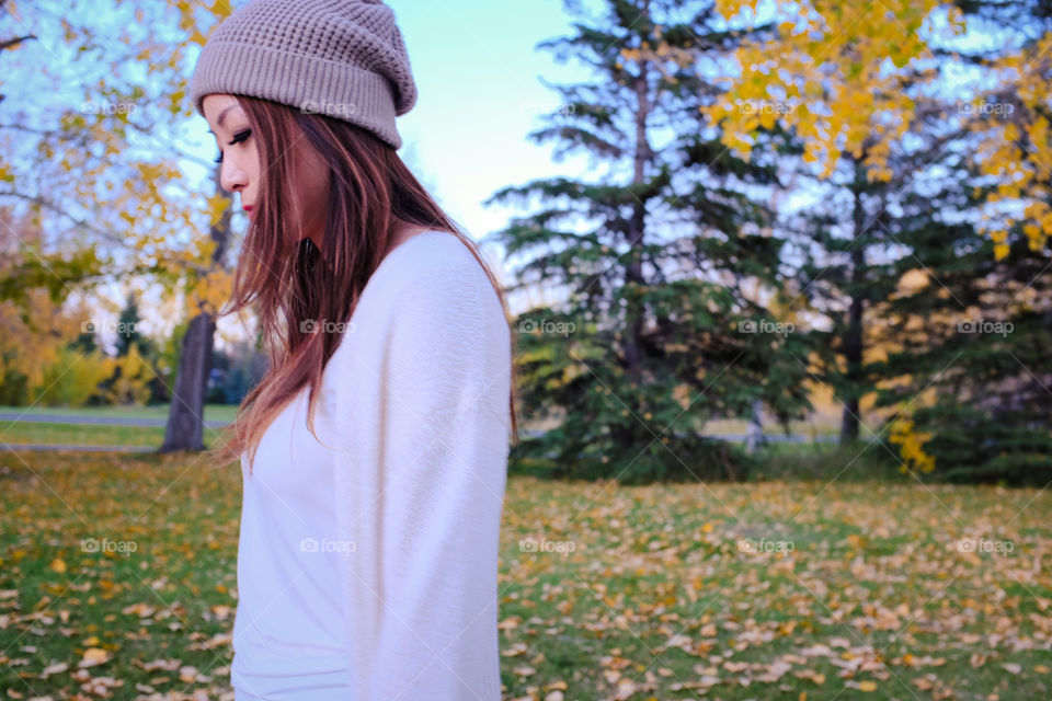 Asian woman on grassy field during autumn