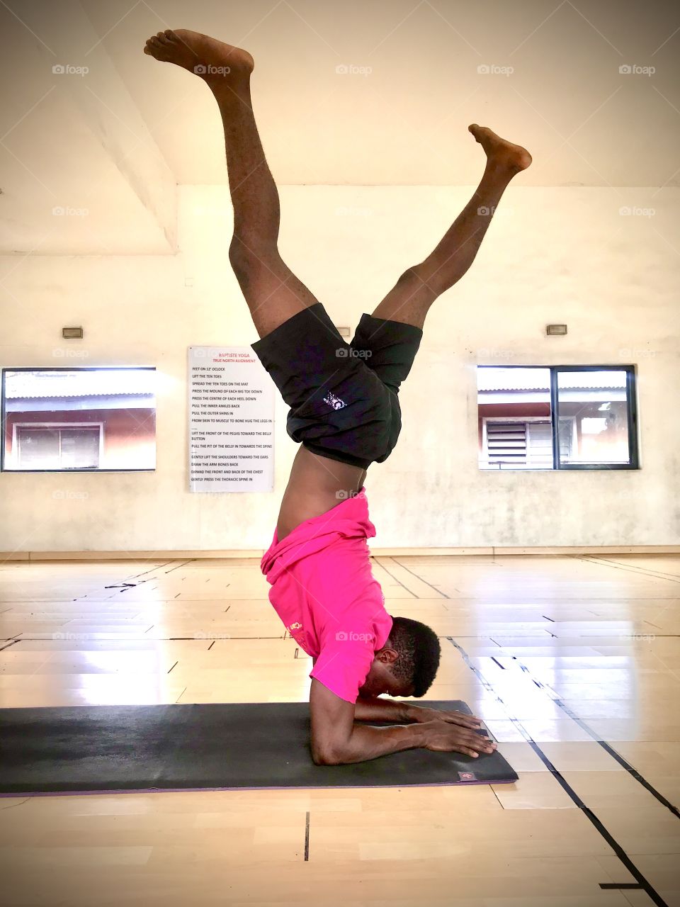 A male yogi demonstrates a pose in a yoga studio 