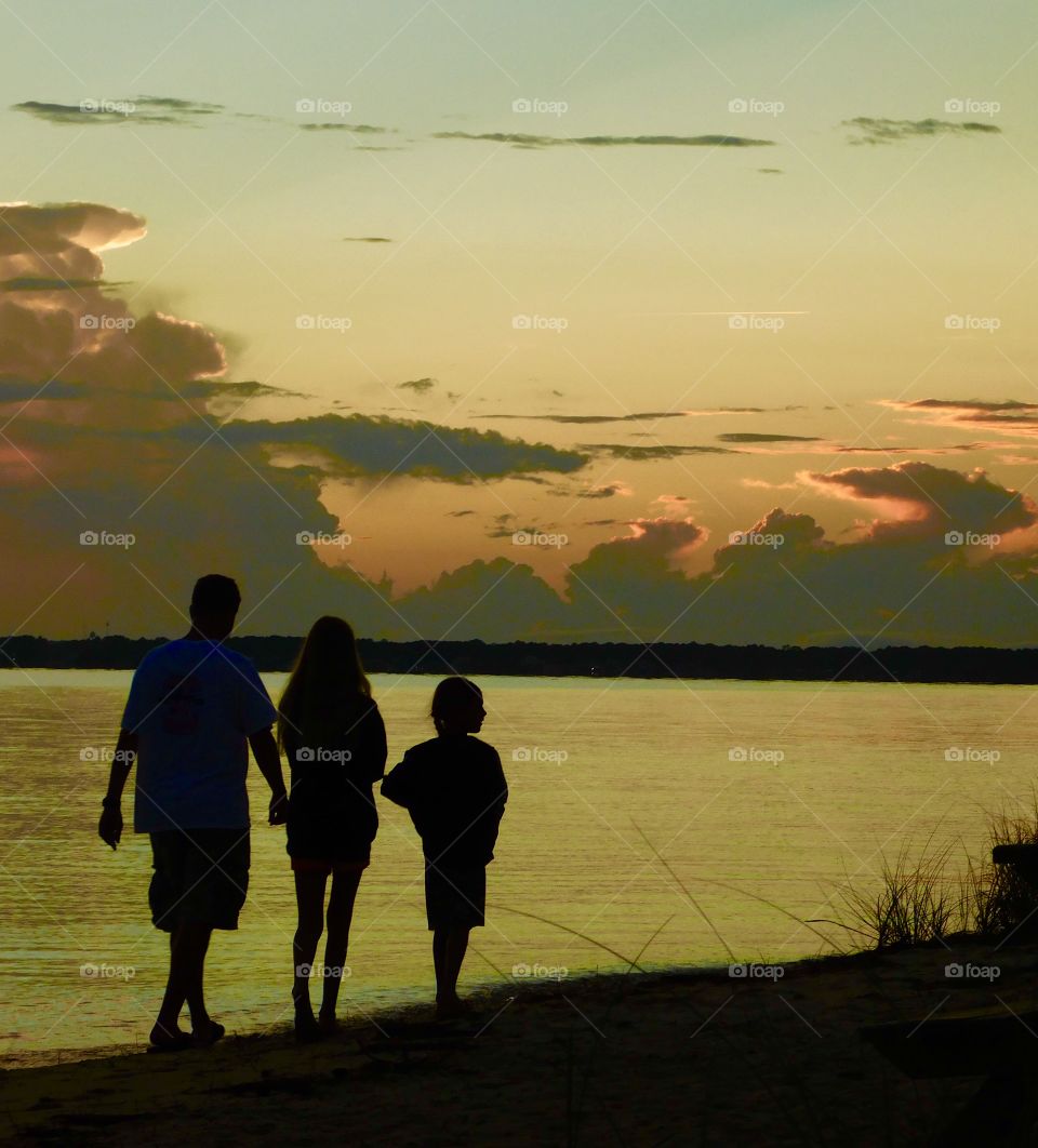 Amazing silhouette of a family walking on the beach 