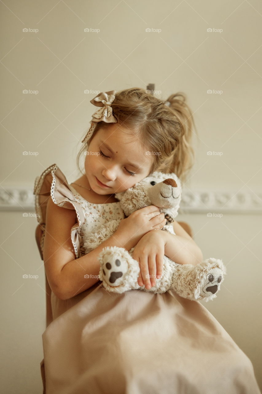 Vintage portrait of a beautiful little girl with teddy bear 