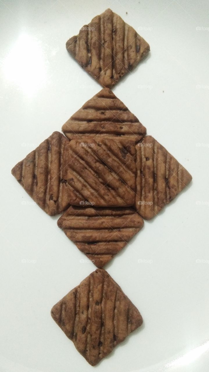 Chocolate cookies arranged on white background.