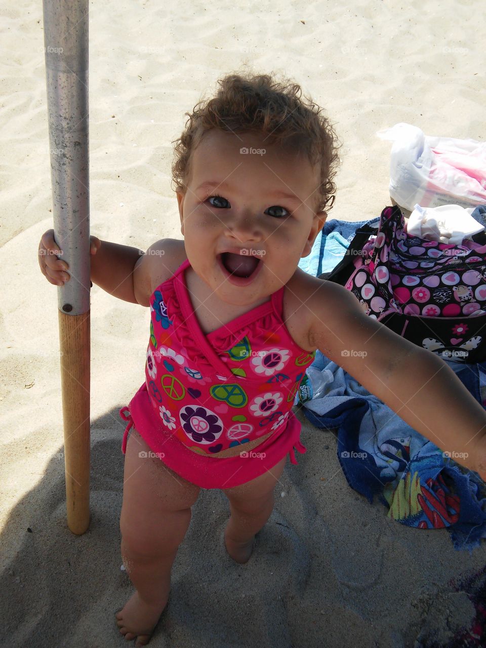 Baby at Beach!!!. 10 month old Tia holding the pole walking around playing hide and seek!!