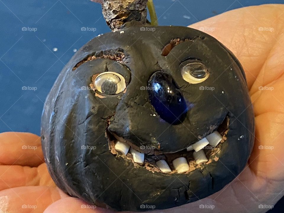 Black clay pumpkin that is handmade. Beads were used for the teeth and nose. Kiln fired.