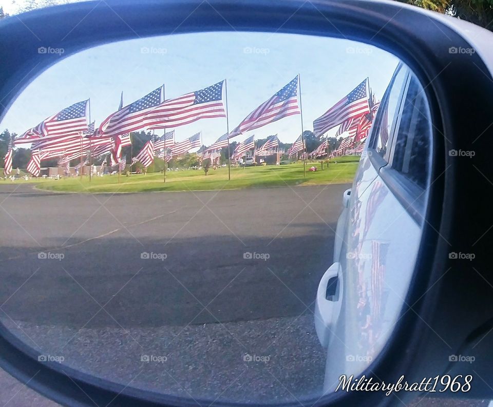 I love to watch the flags blowing in the breeze. This is a beautiful side view mirror picture.