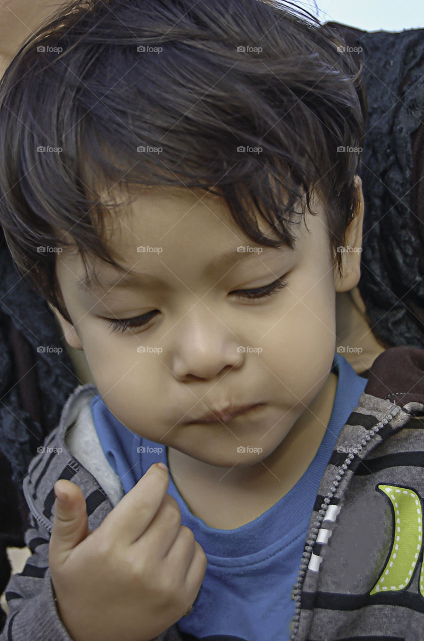 Portrait of Asean boy with short hair wearing a white winter jacket.