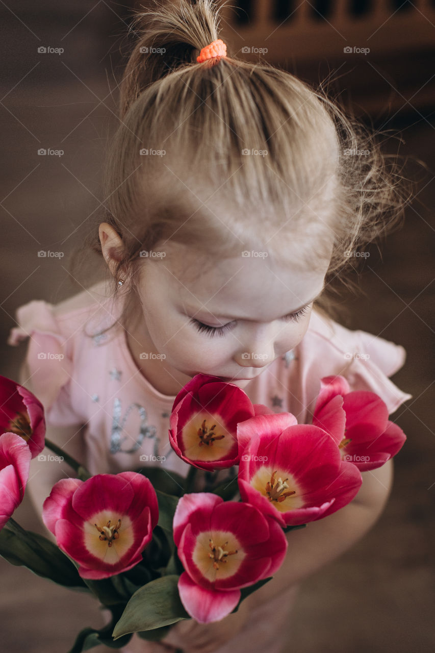 a bouquet of pink tulips in a girl hands