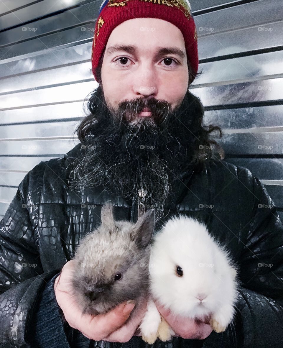 Strange man in a street with two baby rabbits