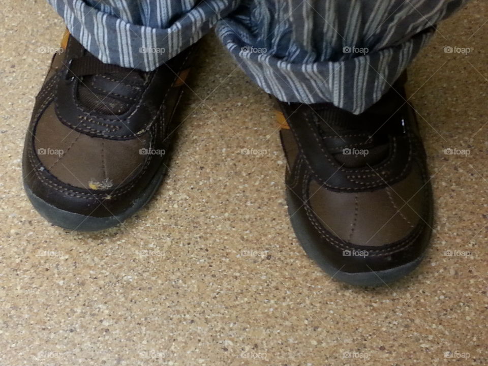 boy's worn shoes. little boy wearing brown shoes